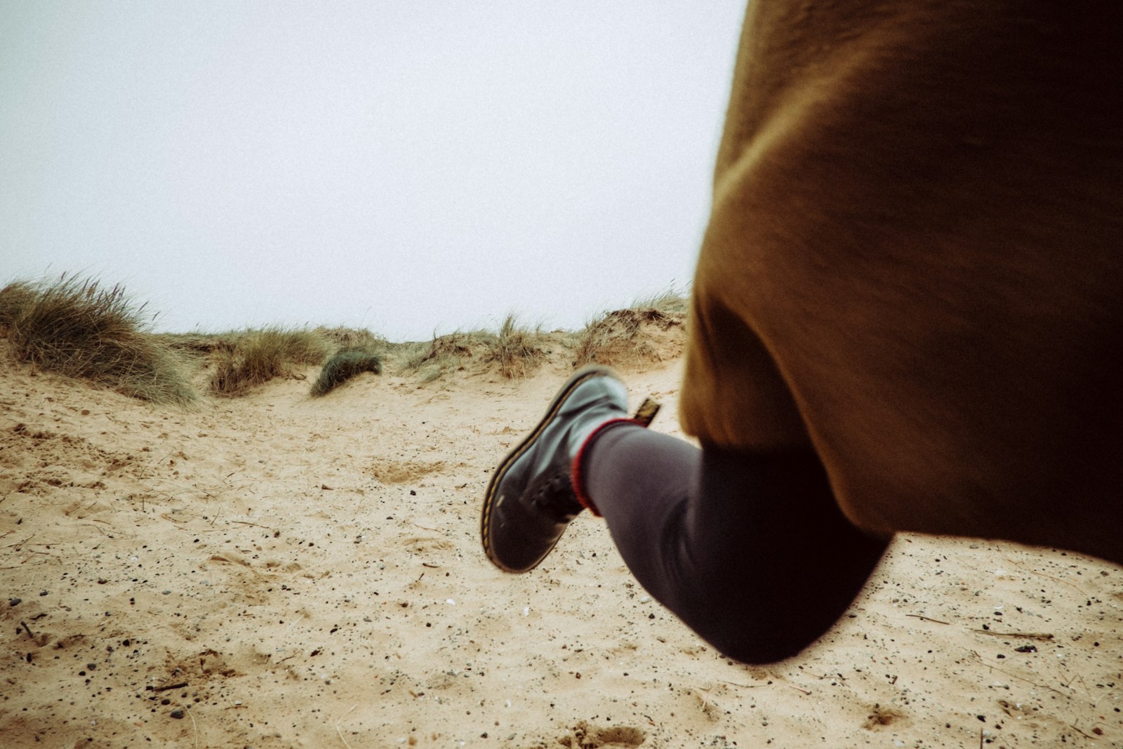 person walking on sandy ground